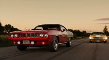 Красный Plymouth Cuda лидирует в гонке с Dodge Challenger